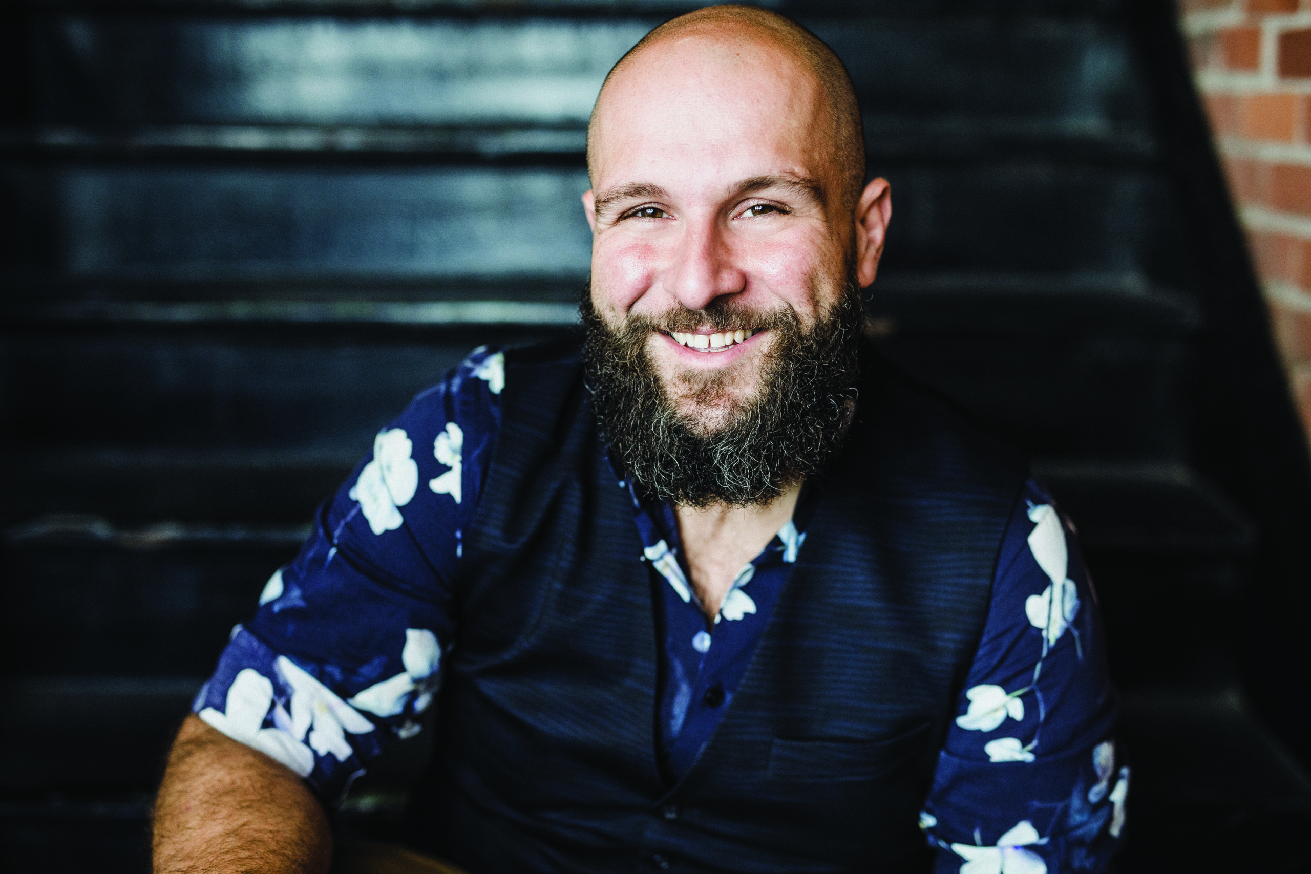 Smiling face of Jacques Arsenault with beard, wearing a blue floral shirt