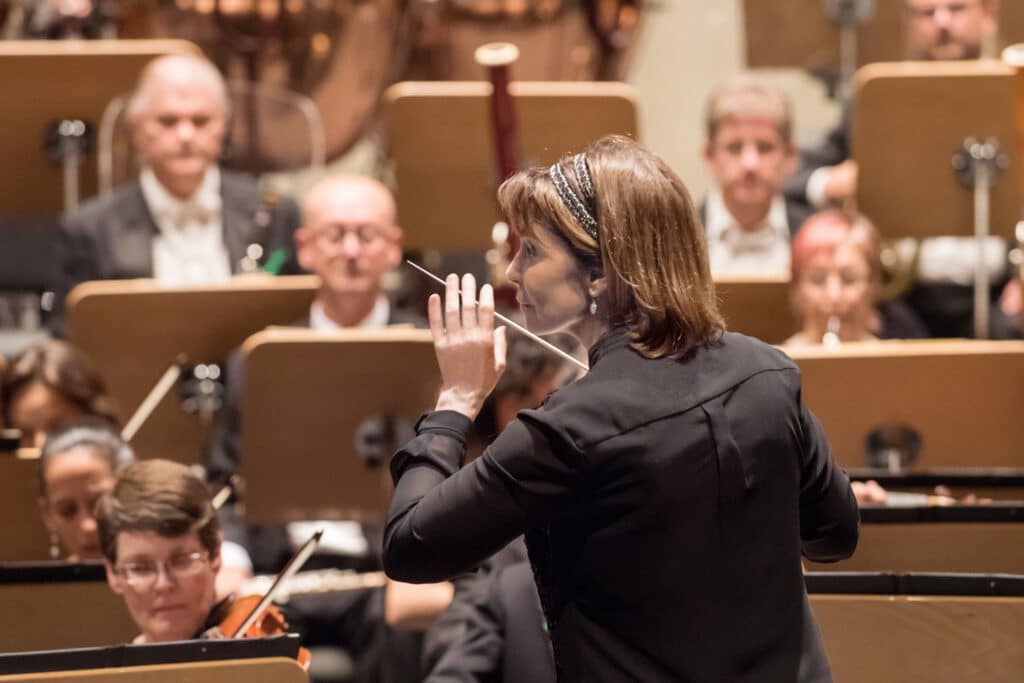 Conductor JoAnn Falletta on the podium conducting an orchestra