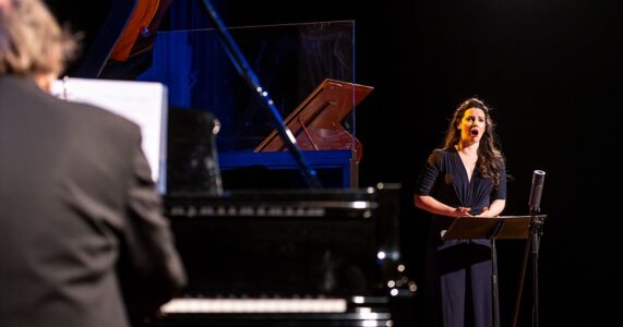 Photo of Mireille Asselin and Frederic Lacroix by Dahlia Katz Mireille Asselin singing, from the perspective over pianist Frederic Lacroix's shoulder