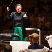 Conducting Fellow Naomi Woo stands on the conducting podium.