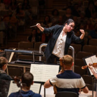 Conducting Fellow Jennifer Tung stands on the conducting podium.